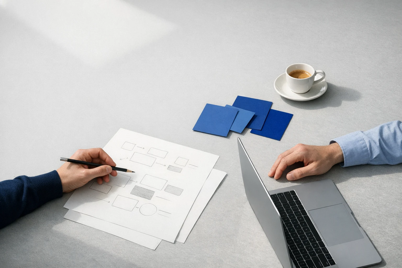 Hands collaborating on a business process at a studio worktable
